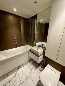 a bathroom with a sink toilet and a mirror at Gunwharf Quays Harbour Apartments in Portsmouth