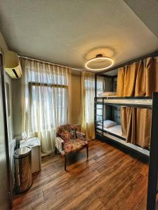 a room with a bedroom with bunk beds and a chair at Nomad Hostel Karaköy in Istanbul