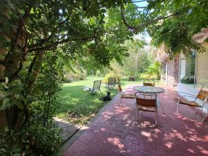 d'une terrasse avec une table et des chaises dans la cour. dans l'établissement Casco El Trapiche, à Godoy Cruz