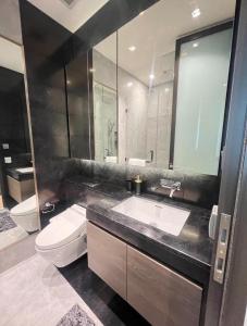 a bathroom with a sink and a toilet and a mirror at Super Luxury Designer Sleeps 6 People in Thonglor in Bangkok