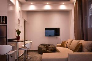 a living room with a couch and a tv on a wall at Galaxyhome in Athens