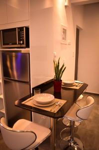 uma cozinha com uma mesa e cadeiras e um micro-ondas em Galaxyhome em Atenas