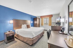 um quarto de hotel com uma cama e uma secretária em City Center Inn em Newport News