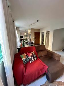 uma sala de estar com um sofá vermelho com almofadas em Apartamento Oxe! Tô na Bahia em Salvador