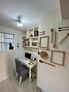 a room with a desk with a laptop and a refrigerator at Apartamento Oxe! Tô na Bahia in Salvador
