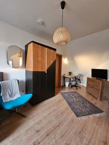 a living room with a blue chair and a desk at StayInn Delitzsch Apartment für bis zu 6 Personen in Delitzsch