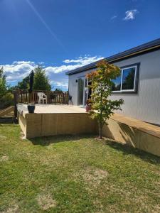 een klein huis met een achtertuin en een patio bij Hillview in Waimate