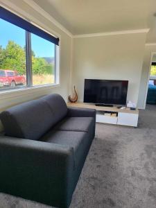 een woonkamer met een bank en een flatscreen-tv bij Hillview in Waimate