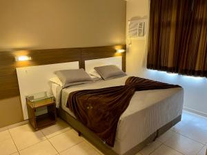 a bedroom with a large bed with a wooden headboard at Brisamar Suite Hotel in Florianópolis