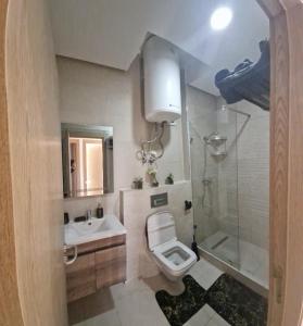 ein Bad mit einem WC, einem Waschbecken und einer Dusche in der Unterkunft Zenata ocean park appartement in Mohammedia