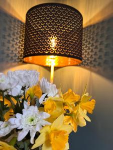 a lamp with a bunch of yellow and white flowers at Entire ground floor town flat - Fully equipped and stunning. in Shrewsbury