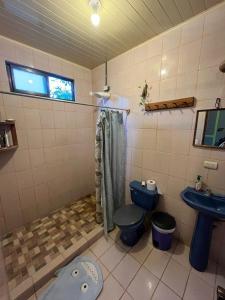 y baño con aseo azul y lavamanos. en Surf House, en Sámara