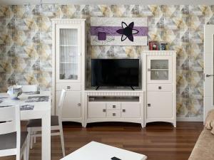 a living room with a tv in a white entertainment center at APARTAMENTOS LONCHO CEE in Cee
