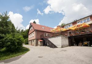 Bystřice pod LopeníkemにあるMonte Lopeのテーブルと傘が備わるレストランを併設する建物