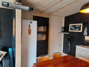 a kitchen with a table and a white refrigerator at Glamp Two-Five-Oh 