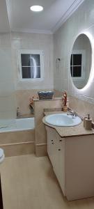 uma casa de banho com um lavatório, uma banheira e um espelho. em Casa Rural La Tejeria 