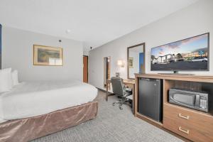 um quarto de hotel com uma cama e uma televisão de ecrã plano em City Center Inn em Newport News
