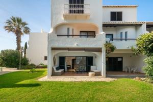 a large white house with a green yard at Arribas Studio in Albufeira