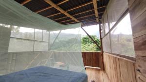 sypialnia z łóżkiem i dużym oknem w obiekcie Sierra Normandia w mieście Cañaveral