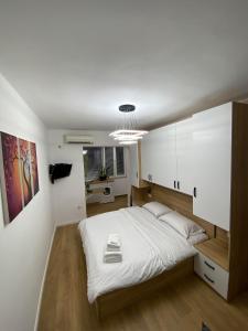 um quarto com uma grande cama branca num quarto em Tirana Apartment em Tirana