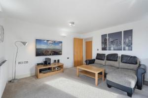 een woonkamer met een bank en een tafel bij Modern 2 bed 2 bath with Balcony in Rayners lane Pinner Harrow near Wembley Greater London in Pinner