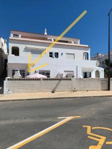 a yellow pole in front of a white building at Anabela Apartment in Carvoeiro