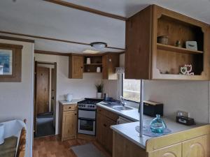 a kitchen with wooden cabinets and a stove top oven at U EGONA in Wejsuny