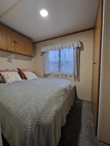 a small bedroom with a bed and a window at U EGONA in Wejsuny