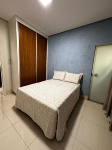 a bedroom with a bed and a blue wall at Casa Impecável in Palmas