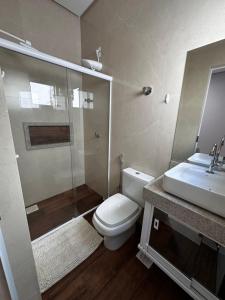La salle de bains est pourvue de toilettes, d'un lavabo et d'une douche. dans l'établissement Casa Impecável, à Palmas