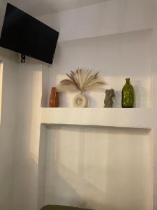 ein Regal mit Vasen und einen TV an der Wand in der Unterkunft Location appartement La Ciotat in La Ciotat