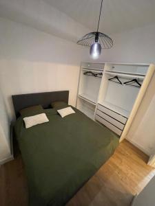 ein Schlafzimmer mit einem grünen Bett und einer Lampe in der Unterkunft Location appartement La Ciotat in La Ciotat