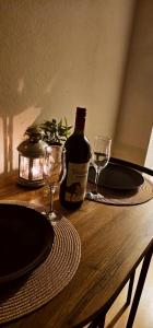 a table with two glasses and a bottle of wine at Apartman 053 in Doboj