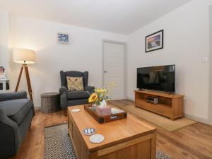 a living room with a couch and a tv at Tŷ Glas in Bridgend