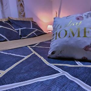 łóżko z niebieskim dywanem i poduszką w obiekcie Apartman 053 w mieście Doboj