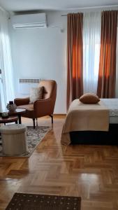1 dormitorio con 1 cama, 1 silla y 1 sofá en Apartman TIM LUX 1, en Vrnjačka Banja