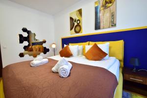 ein Schlafzimmer mit einem großen Bett mit Handtüchern darauf in der Unterkunft Upground Residence Apartments in Bukarest