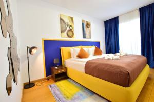 a bedroom with a large bed with blue curtains at Upground Residence Apartments in Bucharest