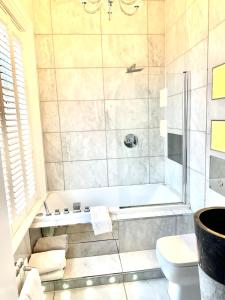 a bathroom with a tub and a toilet at Munstone House in Hereford