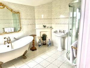 a bathroom with a tub and a sink at Munstone House in Hereford