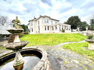 a fountain in front of a large house at Munstone House in Hereford