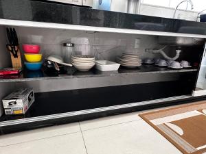 uma cozinha com pratos e utensílios numa prateleira em Casa Impecável em Palmas