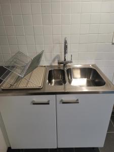 a kitchen sink with a laptop on the counter at Vila Ösmo in Ösmo