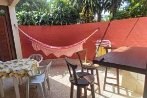 een patio met stoelen, een hangmat en een tafel bij Espaço inteiro: casa Manguinhos/Geribá in Búzios
