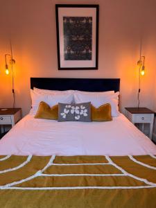 1 dormitorio con 1 cama blanca grande y 2 lámparas en Entire ground floor town flat - Fully equipped and stunning., en Shrewsbury