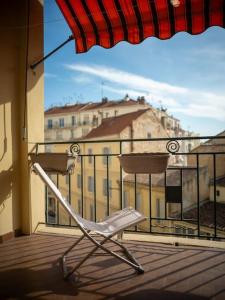 een stoel op een balkon met uitzicht op een gebouw bij Appartement tout équipé avec terrasse au cœur de Marseille in Marseille