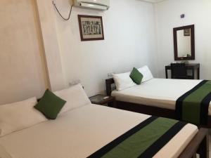 a room with two beds and a mirror at Seasons Villa in Dambulla