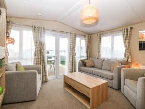 a living room with two couches and a coffee table at Seafront Holiday Home 2 in Pwllheli