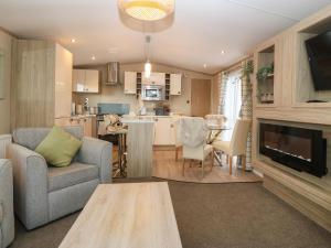 una sala de estar con un sofá y una mesa en Seafront Holiday Home 2, en Pwllheli