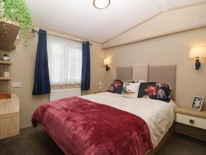 a bedroom with a large bed and a window at Seafront Holiday Home 2 in Pwllheli